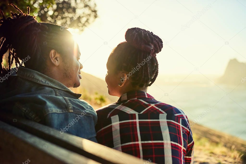 Couple of African descent sitting on a public viewpoint bench