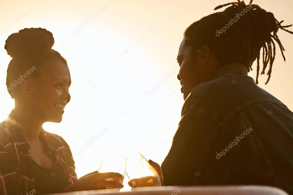 Silhouette of a couple making a toast during golden hour