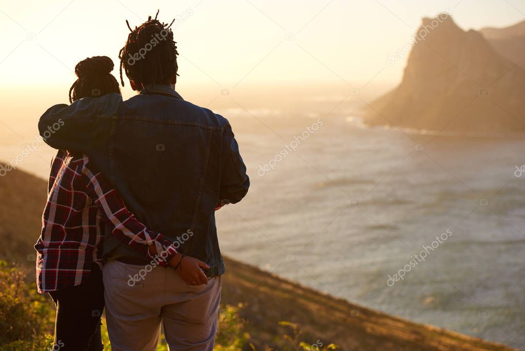 Mixed race couple standing together watching the view from behind