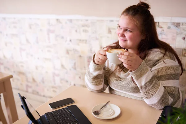 Young adult chubby woman holding a coffee while smiling — Stock Photo, Image