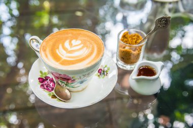 Latte Kahve kahverengi şeker ve şurubu kavanoz cam masa üzerinde. 