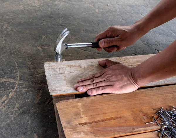 Carpintero clavando tablero de madera para hacer muebles —  Fotos de Stock