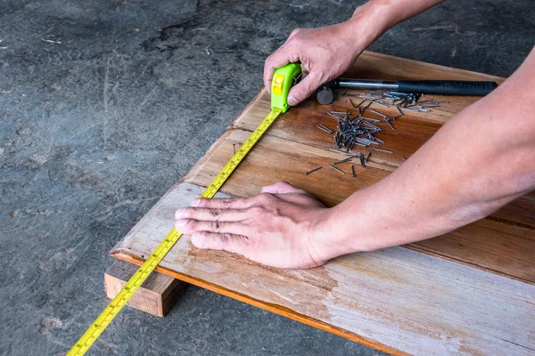 Carpintero que mide la distancia del tablero de madera cuando hace un fu de madera —  Fotos de Stock