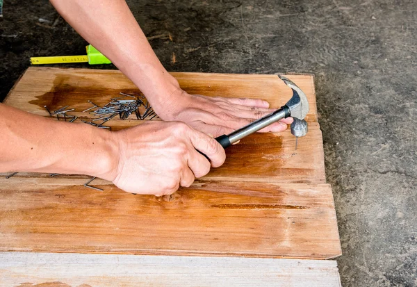 Carpintero clavando tablero de madera para hacer muebles —  Fotos de Stock