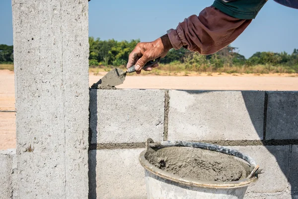 Travailleur faire mur de béton par bloc de ciment et de plâtre à constru — Photo