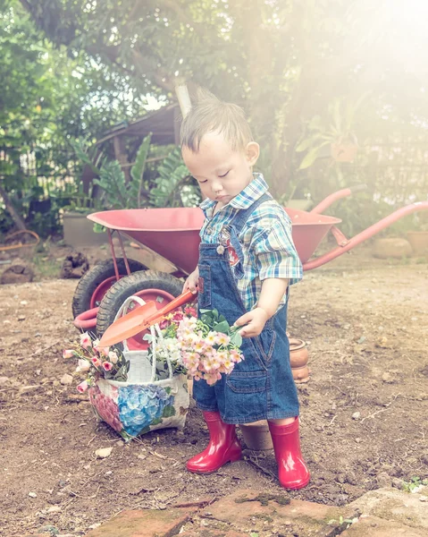 Il giardiniere. Asiatico bambino maniglia giardino cucchiaio, luce e vi — Foto Stock