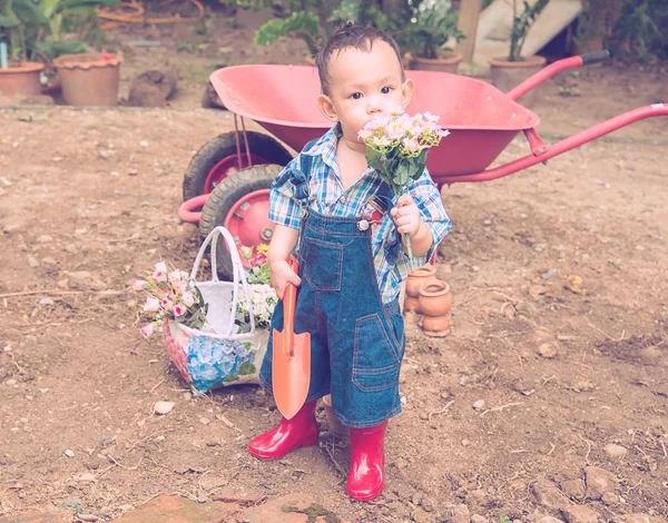 Baby gardener. Asian baby boy handle garden spoon  and flower — Stock fotografie