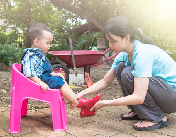 Mother wearing red color boots to baby and talking together  , F — Stock Photo, Image