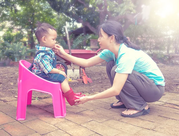 Mother wearing red color boots to baby and talking together  , F — Stock Photo, Image