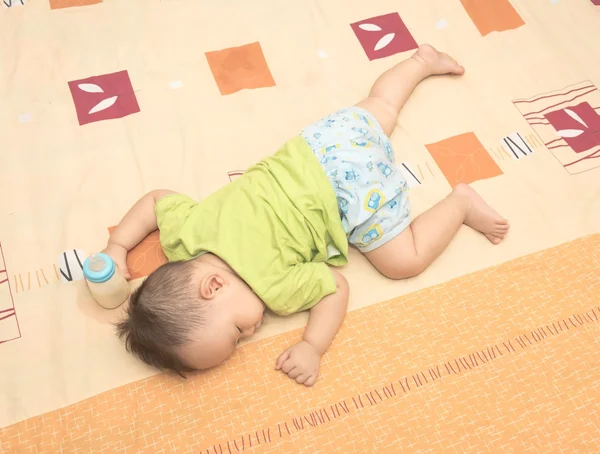 Baby sleeping in his hand holding baby milk bottle — Stock Photo, Image