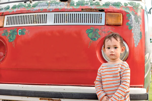 Outdoor portrait of Asian baby boy who standing in front of old mini van, vintage and retro style — Stock fotografie