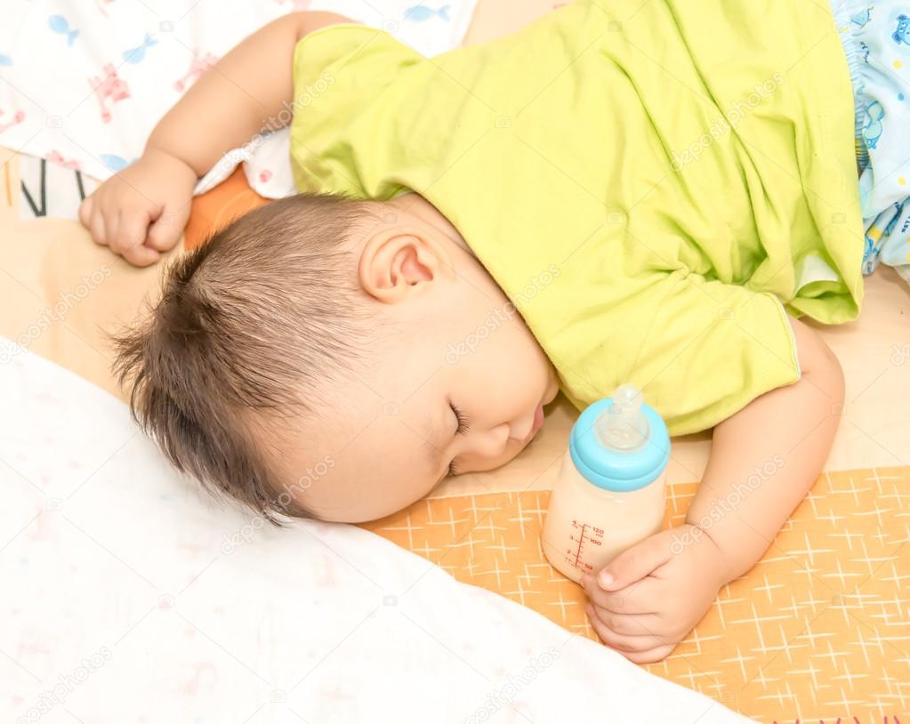 hand  holding milk bottle while sleeping