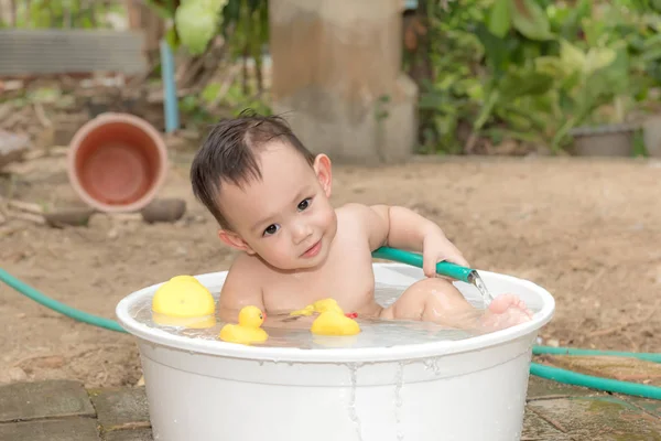 Vue de dessus Bébé garçon asiatique baignade en plein air dans la baignoire blanche. H — Photo