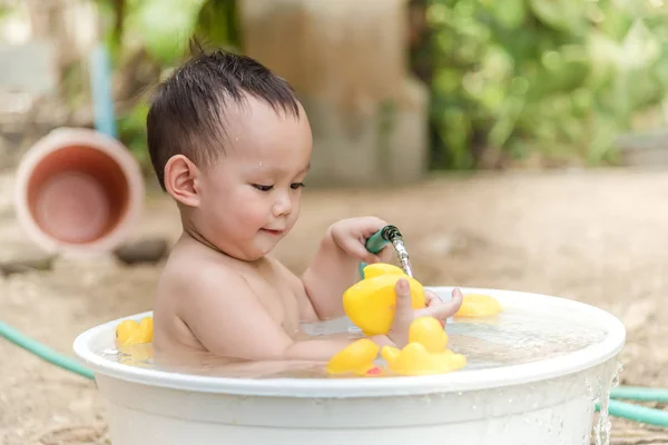 Top view Asian baby boy outdoor bathing in the white bathtub . H — Stock Photo, Image