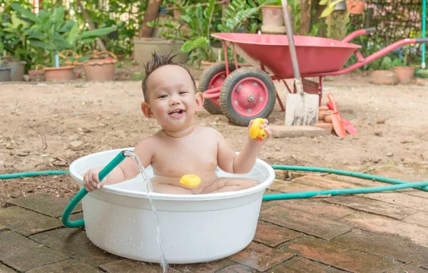 Top view Asian baby boy outdoor bathing in the white bathtub . H — Stock Photo, Image