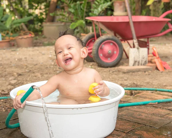 Top view Asian baby boy outdoor bathing in the white bathtub . H — Stock Photo, Image