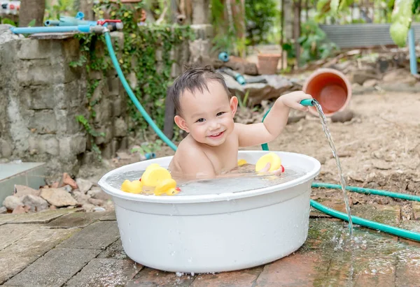 Top view Asian baby boy outdoor bathing in the white bathtub. H — стоковое фото