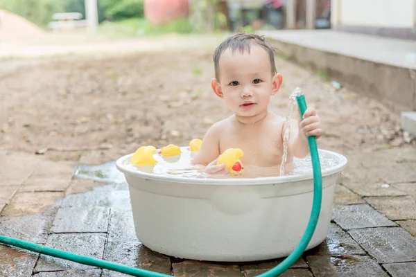 Top view Asian baby boy outdoor bathing in the white bathtub . H — Stock Photo, Image