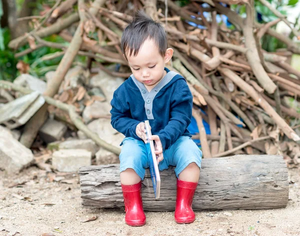 Asijské dítě chlapec čtení příběh knihy, The Boy opotřebení červená bota sedí — Stock fotografie