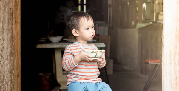 Азіатський хлопчик їсть смаженим рисом по ложці ним самоврядування — стокове фото