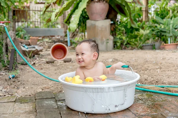 Top view Asian baby boy outdoor bathing in the white bathtub . H — Stock Photo, Image