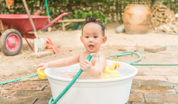 Top view Asian baby boy outdoor bathing in the white bathtub . H — Stock Photo, Image