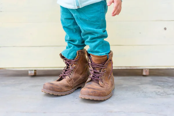 Chlapeček se snaží nosit boty otce — Stock fotografie