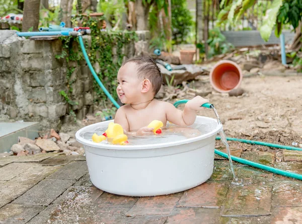 Top view Asian baby boy outdoor bathing in the white bathtub . H — Stock Photo, Image