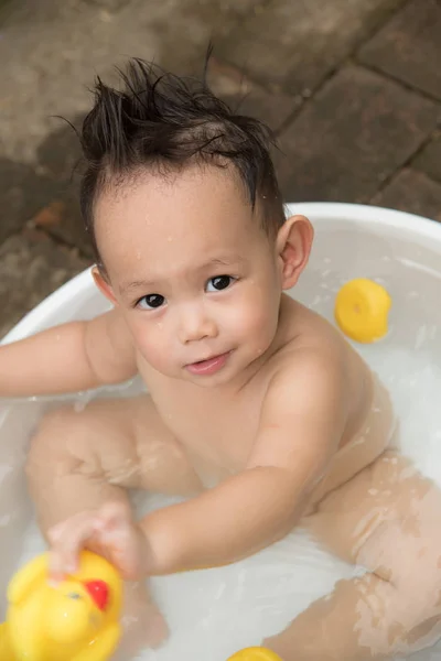 Top melihat bayi Asia anak laki-laki luar ruangan mandi di bak mandi putih. H — Stok Foto