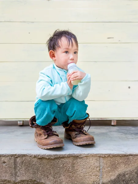 Thajské chlapeček se snaží nosit boty otce — Stock fotografie