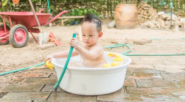 Top view Asian baby boy outdoor bathing in the white bathtub . H — Stock Photo, Image