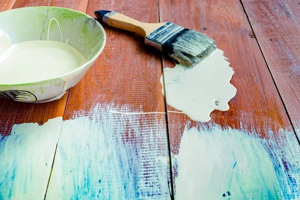 Paint brush and  bowl  of white coating color