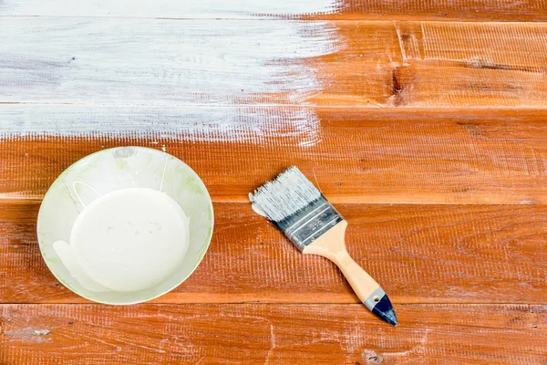 Paint brush and  bowl  of white coating color