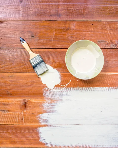 Paint brush and  bowl  of white coating color