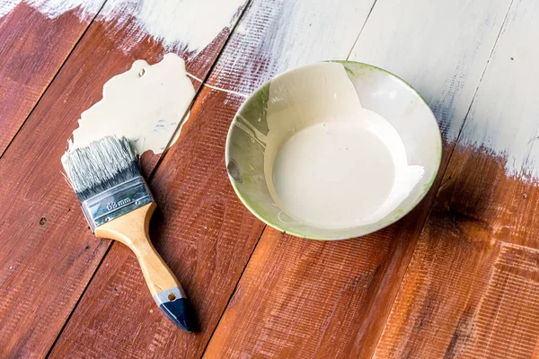 Paint brush and  bowl  of white coating color