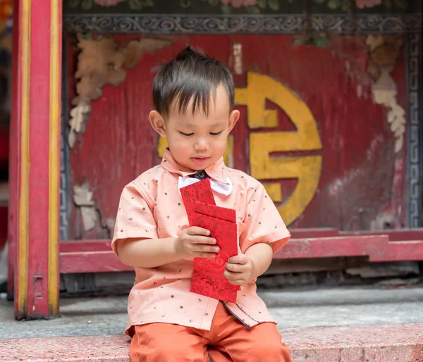 Asijské chlapeček drží červenou obálku nebo Ang pow . — Stock fotografie