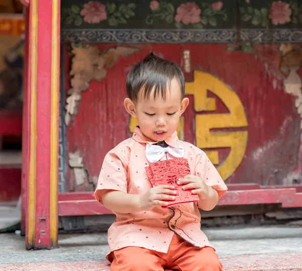 Asijské chlapeček drží červenou obálku nebo Ang pow . — Stock fotografie
