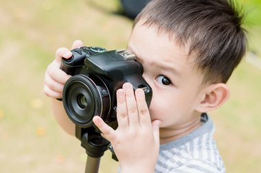 Yakışıklı Asyalı çocuk tarafından dijital SLR bir fotoğraf almak 