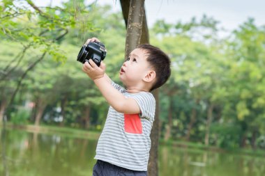Yakışıklı Asyalı çocuk tarafından dijital SLR bir fotoğraf almak 