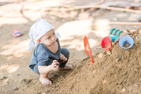 Thajské baby boy palying na hromadu písku s hračkou — Stock fotografie