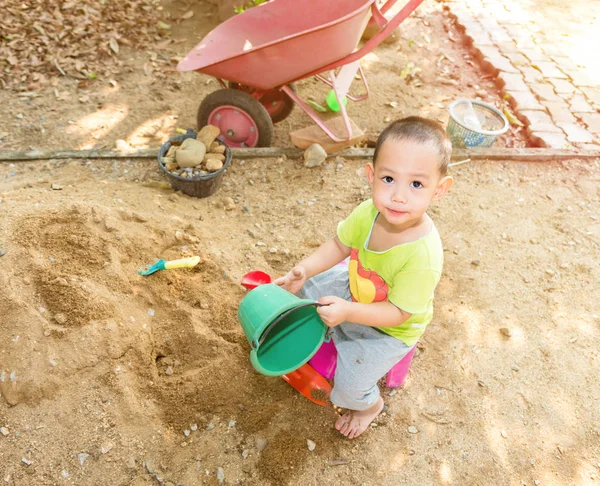 Thajské baby boy palying na hromadu písku s hračkou a plastových vidlice — Stock fotografie