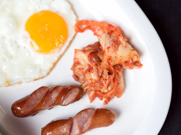 La salchicha de huevo frito y Kimchi sirven como desayuno en blanco —  Fotos de Stock