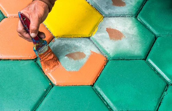 El trabajador de mampostería pintando bloque de pavimentación por cepillo de aire de color y — Foto de Stock