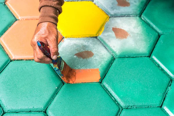 El trabajador de mampostería pintando bloque de pavimentación por cepillo de aire de color y — Foto de Stock