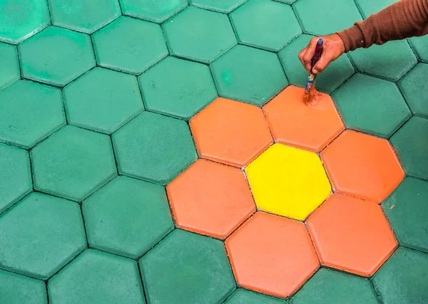 El trabajador de mampostería pintando bloque de pavimentación por cepillo de aire de color y — Foto de Stock