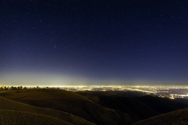 Gece gökyüzünde tam yıldız, Mottarone tepe (Piedmont, Kuzey İtalya); en baştan görüntülemek arka planda Padana büyük şehir pianure (Milano gibi ışıklar).
