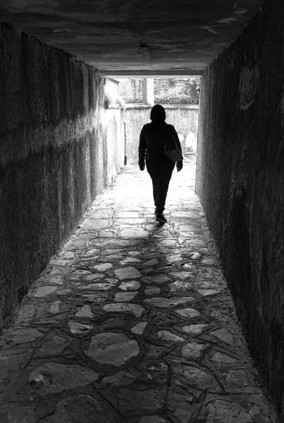 一个人走在黑暗的隧道 向着日光 — 图库照片
