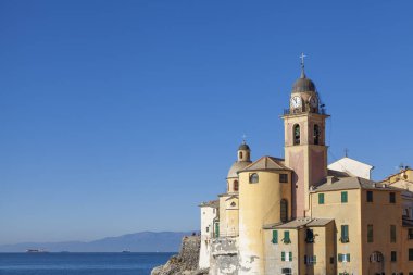 The characteristic church of Santa Maria Assunta of Camogli, built over the cliffs of Ligurian Sea. Camogli is a small fisherman village on the shores of the Ligurian Sea. (Northern Italy); during summertime became full of tourists.