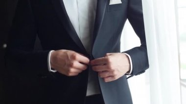 Şık erkek takım elbise ceket düğmeleri takılır yavaş yakından dışarı çıkmak hazır olun. Pencere yakınındaki hiçbir yüz adam düğmeleri ceket yaka cep Meydanı düzeltiyor. Kuruluş liderlik moda başarı