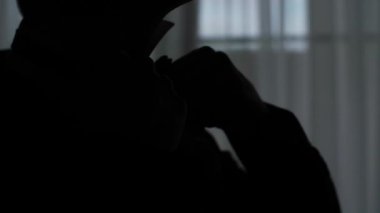 Erkek düğmeleri gömlek ayarlar ve papyon yakın ağır çekim kadar kontrast düzeltiyor. Yüzü olmayan ayarlar tanınmaz tuhaf kişi uygun giysiler pencere koyu siyah resim anonim yakınındaki 